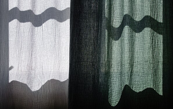 Wave-shaped shadows cast on a curtain