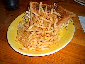 A Club sandwich with fries