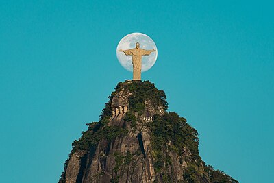 Patung Kristus Penebus di Rio de Janeiro, Brasil, dengan latar belakang Bulan
