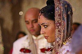 Hindu-Braut mit Bindis und Maang Tikka im Scheitel, wo verheiratete Frauen Sindoor-Pulver auftragen