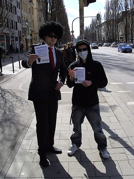File:"Anonymous" members with flyers, at anti-Scientology protests (Munich 2008).jpg