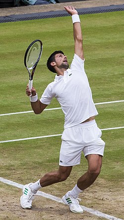 A tennis player holds a racket in his hand