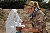 Den 11 augusti 2003 tar NATO över ledningen för ISAF:s (International Security Assistance Force) insatser i Afghanistan. Även Sverige bidrar med militära och civila insatser i denna mission: Bilden visar en svensk officer i arbete med ett medicinskt hjälpprojekt för afghanska kvinnor.