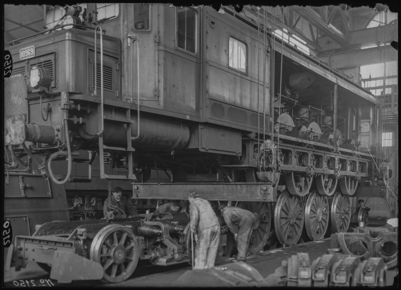 File:SBB Historic - F 108 01-02150 - Absenken des Rahmens in die Achsen bei Lokomotive Ae 4 7 10969 in der Werkstaette Zuerich.tif