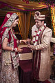 હિંદુ ભારતીય લગ્નમાં સાડીમાં સ્ત્રી અને શેરવાનીમાં વર.