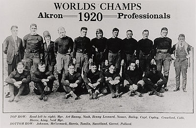 Un grup de 18 bărbați, 11 stând în spate și șapte stând în față. Deasupra bărbaților, centrat în mijlocul afișului, este textul pe care scrie „Worlds Champs”. Sub aceasta se află sintagma „Akron Professionals” – anul 1920 este plasat între „Akron” și „Professionals”.