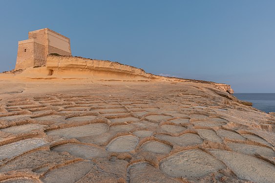 Salt pans and Xlendi Tower, Gozo Island, Malta.