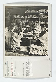 Four men weigh bundles of raw silk in Japan, in September 1918.