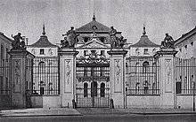 Brama klasycystycznego Pałacu Brühla, z sylwetką samego pałacu w tle. Zdjęcie czarno białe.