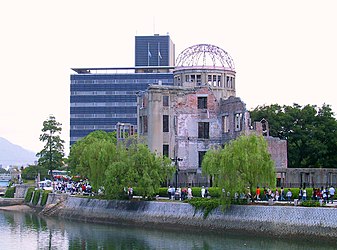 Citizens of the city pass by the Hiroshima Peace Memorial on their way to a memorial ceremony on 6 August 2004