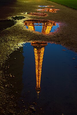 Reflection of the Eiffel Tower in a puddle of water, Paris, France.