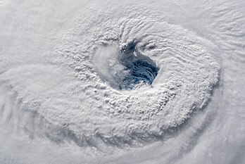 Foto do furacão Florence, uma tempestade de categoria 4, tirada da Estação Espacial Internacional em 11 de setembro de 2018, pelo astronauta Alexander Gerst, enquanto Florence atravessava o Oceano Atlântico na direção oeste-noroeste, com ventos de 210 quilômetros por hora. Florence foi um furacão poderoso e de longa duração em Cabo Verde que causou danos catastróficos nas Carolinas em setembro de 2018, principalmente como resultado de inundações de água doce devido a chuvas torrenciais. O sexto ciclone nomeado, o terceiro ciclone tropical, e o primeiro grande furacão da temporada de furacões no Atlântico de 2018. (definição 5 322 × 3 558)