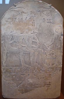 男が息子と妻と共に腰掛けており、その右に立つ男が献酒をしているところを描いたレリーフのある石碑。石碑の底部にはくっきりとした水平方向の罫線があり、ヒエログリフが書かれている。
