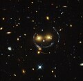 Citra "smiley" - gugusan galaksi (SDSS J1038+4849) & lensa gravitasi (sebuah cincin Einstein) (HST).[7]