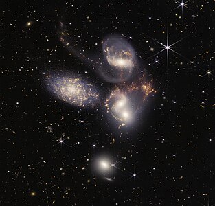 2022年にジェイムズ・ウェッブ宇宙望遠鏡 (JWST) の近赤外カメラNIRCamと中間赤外線装置MIRIを使って撮像された「ステファンの五つ子」の合成画像。