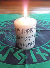 Kerze mit Runen der jüngeren Runenreihe auf Tischdecke mit Runen der älteren Runenreihe - Aufnahme von 2017