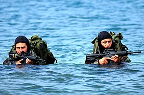 Basic Underwater Demolition-SEAL (BUD-S) alunos desembarcam em uma ilha durante um exercício