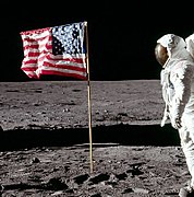 Foto recortada tirada alguns segundos depois, a mão de Buzz Aldrin está para baixo, a cabeça virada para a câmera, a bandeira mantém-se inalterada