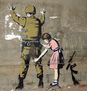 İngilizce Guerilla Artist yani "Gerilla Sanatçı" olarak ünlenen İngiliz sanatçı Banksy'nin Betlehem'de yer alan siyasî içerikli bir graffiti çalışması. (Üreten:Fotoğraf: Pawel Ryszawa, Eser: Banksy)