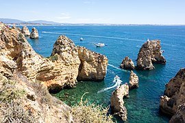 Os 65 993 km (41 006 mi) de litoral dominam o clima europeu (Ponta da Piedade, Portugal)