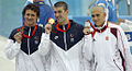 Amerikaneren Michael Phelps, 14-dobbelt OL-guldmedaljevinder, i midten med én af de otte guldmedaljer, han vandt under OL i Beijing. Til venstre ses sølvvinderen Ryan Lochte (USA) og til højre Laszlo Cseh (Ungarn).