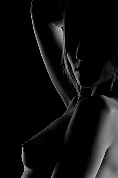 Foto em preto-e-branco com iluminação low-key de um nu feminino. (definição 2 832 × 4 256)