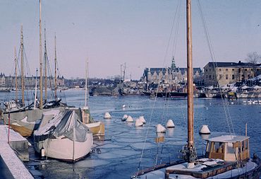 Stockholms stadslandskap präglas av stadens läge mellan Mälaren och Östersjön. På detta fotopar visas två vinterbilder över Ladugårdslandsviken mot öst från Museikajen intill Skeppsholmsbron. På bilden till vänster från 1965 syns Kaknästornet längst bort. Tornet är fortfarande under byggnad och invigdes två år senare. Vid kajen på Skeppsholmen ligger Svenska flottans krigsfartyg, det gjorde de fram till 1968. Längst till höger skymtar Råseglarhuset och i bakgrunden syns Nordiska museet.