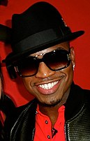 Representado com um pano de fundo vermelho, está um homem de raça negra a sorrir, com um chapéu e óculos pretos como adornos. Tem vestido uma camisa vermelha e um casaco negro, com dois brincos na sua orelha esquerda.