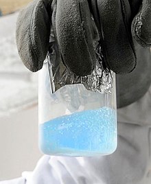 Prozorna čaša, ki vsebuje svetlo modro tekočino z mehurčki