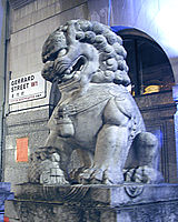 A stone lion on Gerrard Street. Note the bilingual English/Chinese street sign in the background.