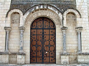 Le portail avec des colonnes et des chapiteaux pouvant provenir de la basilique mérovingienne.