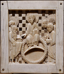 一个象牙雕刻盘，上面刻着一个头顶光环的大胡子从一个戴着王冠的人手中接过教堂的比例模型