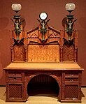 Desk; designed by Frank Furness, made by Daniel Pabst; 1870–1871; walnut, walnut veneer, rosewood (knobs), brass, iron, steel and glass; 196.9 × 157.5 × 81.9 cm; Philadelphia Museum of Art (Philadelphia, USA)[67]