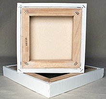 A square canvas rests on top of another with its back showing a thick frame of wood.