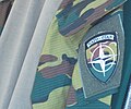 емблема НАТО на шевроні бельгійського камуфляжного однострою (бронежилет)