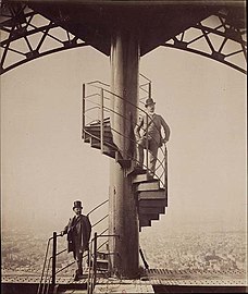 Gustave Eiffel (left) posing on the stairway of his tower