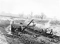 イギリス国立鉄道博物館にも展示されている写真（1920年9月）。狭軌の鉄道と、そこを走る蒸気機関車Pixie。おそらく露天掘り採石場で、蒸気を動力として動く機械で石を積み込んでいる。