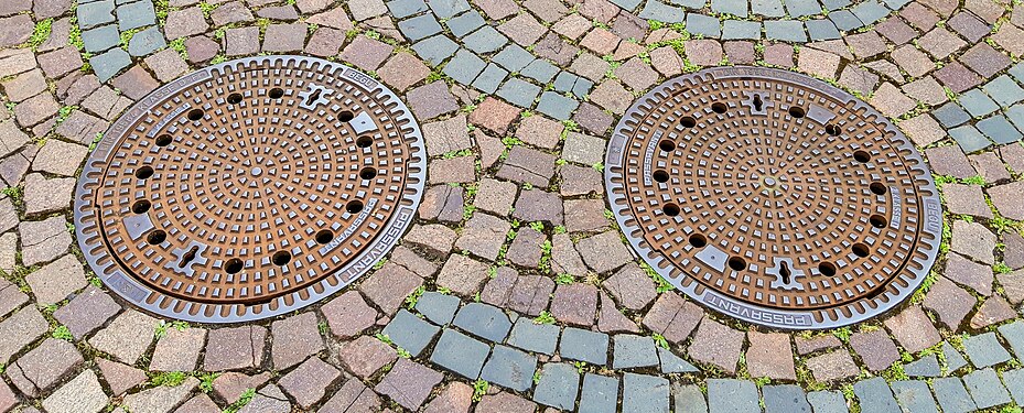 Two round manhole covers on manholes