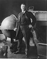 Portrait of Theodore Roosevelt posing next to a large globe