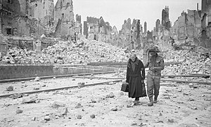 Britisk soldat i Caen, med sivil kvinne, etter bombingen