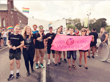Photograph of a group of people, some of whom are carrying a banner with the text "LGBT+" and "Wikimedia"