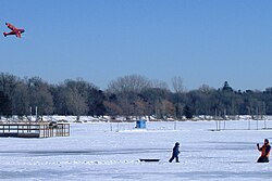 Människor flyger drake vid Lake Harriet, frusna och övertäckta med snö