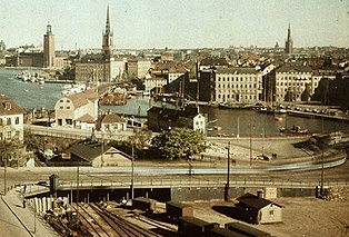 En blick över Slussen före och efter att Slussens trafikkarusell byggdes visar stora förändringar i stadslandskapet. Trafiken på vattnet, på järnvägsspår och på land möttes vid Slussen och skapade "slusseländet". Problemet löstes med invigningen av nya Slussen 1935. Sedan dess har även Centralbron och tunnelbanan förändrat stadsbilden. Bilden till vänster är från 1928, bilden till höger från 2005, vy mot nordväst med Gamla stan i bakgrunden, Stockholms stadshus till vänster och Riddarholmskyrkans torn närmast mitten. Fotografiet från 1928 togs av Gustaf W. Cronquist.