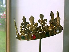 Photographie d'une couronne dorée en équilibre sur un bâton.