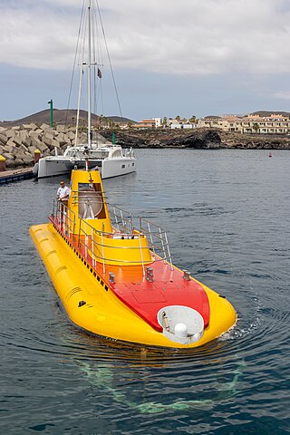 The tourist submarine Sub Fun Cinco being steered from deck into its port at Marina San Miguel, Tenerife