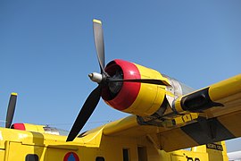 Vue depuis le sol d'une aile jaune avec un moteur rouge sous l'hélice.