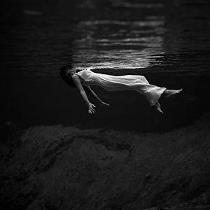 צילום תת-מימי בשחור לבן של אישה הצפה על פני המים, צולם בפלורידה ב-1947 בידי הצלמת האמריקאית טוני פריסל.
