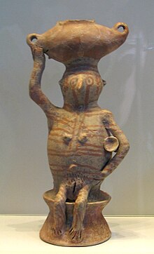 Peça de cerâmica representando uma mulher carregando uma bacia em sua cabeça