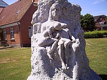 Stone statue of a seated female figure with two children on her lap