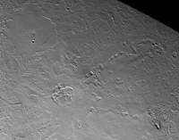 Close up of the volcanic province of Leviathan Patera, the caldera in the center of the image. Kraken Catena and Set Catena extend radially from the caldera to the right and upper-right of the image, while Ruach Planitia is seen to the upper left. Just off-screen to the lower left is a fault zone aligned radially with the caldera, indicating a close connection between the tectonics and volcanology of this geologic unit.
